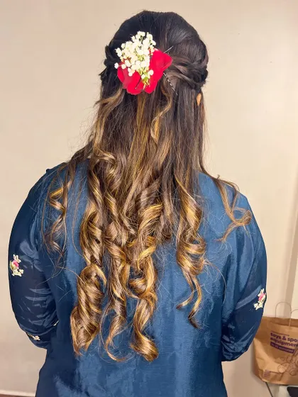 Soft curls with a braided crown and floral accessories. This hairstyle is perfect for an Indo-western outfit.