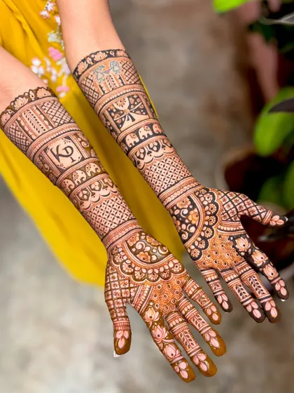 Kavitha's wedding mehendi, a beautiful example of personalized bridal art with the couple's initials "KP" and symbolic motifs like elephants and butterflies.
