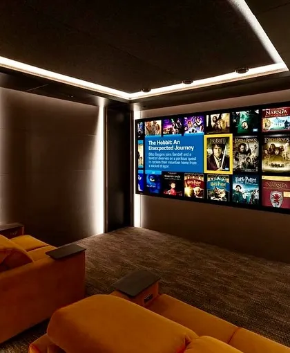 Another view of the orange-themed theater, showcasing the large screen and how the warm colors of the room complement the on-screen visuals.