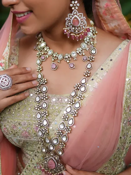 A close-up of the layered necklaces, showing the delicate floral and teardrop-shaped Polki stones.