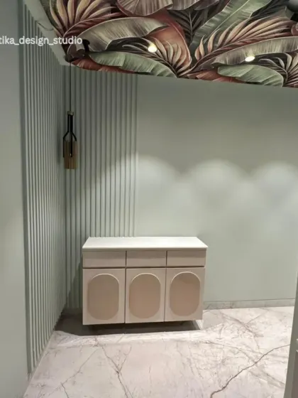 This passage is transformed into a design moment with a bold, tropical-print ceiling. The soft, pastel green walls are accented with fluted paneling and a minimalist console table, creating a chic and unexpected vignette.