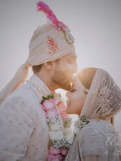 A tender forehead kiss from the groom at sunset, a perfectly romantic and cinematic shot.