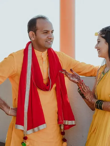 Aishwarya and Prasad share a conversation during their Haldi ceremony. The natural interaction and relaxed posture make this a lovely, authentic pre-wedding photo.