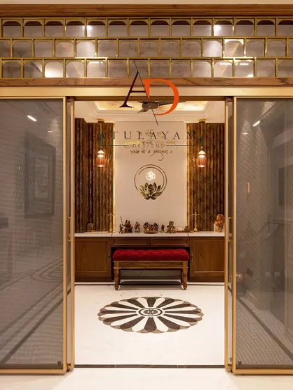 Another view of a pooja room entrance, this time leading to a space with wooden slat walls and a central 'Om' symbol.