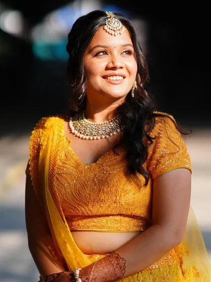 The bride is glowing in the sunlight. The makeup is designed to enhance her radiance.