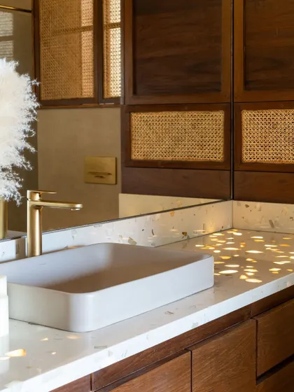 A detail of the custom vanity, showing the warm tones of the wood and cane.