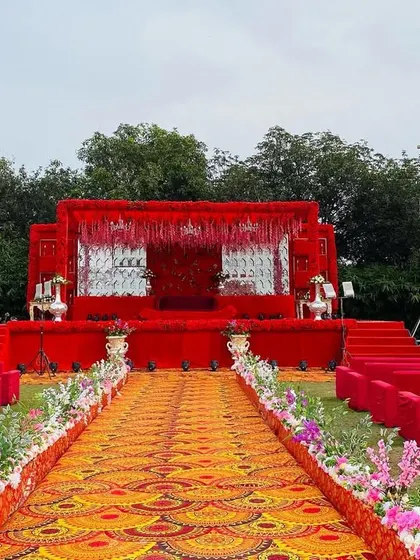 A wide shot of the all-red stage, showing the guest seating and the impressive scale of the setup.