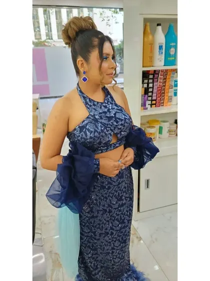 A side profile of our party makeup and hair styling. This view highlights the expertly done high bun and the contouring that defines the client's features, creating a polished and glamorous look.