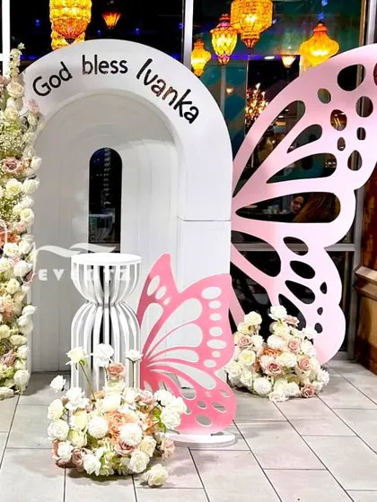 This butterfly-themed decoration for a First Holy Communion shows our modern and creative approach. The design uses custom-cut butterfly wings, elegant white arches, and beautiful floral towers for a whimsical and blessed celebration.