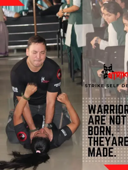 A female student practices a ground escape technique on an instructor during a school workshop. The text says it all: "Warriors are not born, they are made." We build them here, one technique at a time.
