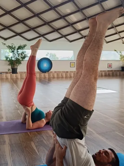 A closer view of guests in Sarvangasana (Shoulder Stand). This inversion is known for its benefits in calming the brain, reducing stress, and improving circulation.