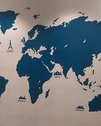 A custom world map mural painted in a solid color, perfect for a study or living room to inspire wanderlust and mark travel destinations.