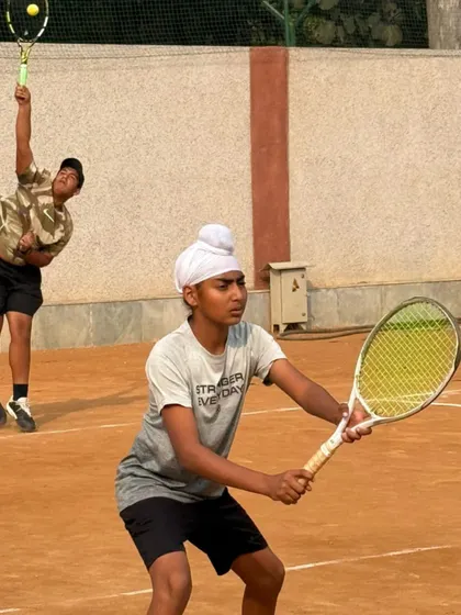 A doubles practice session, with one player at the net and the other serving. Teamwork and communication are key skills we teach for doubles play.