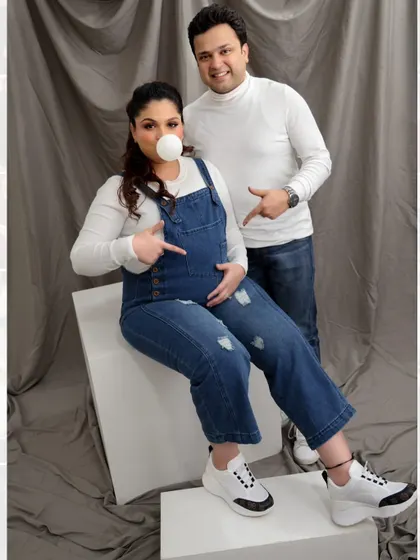 We also love to capture your playful side. This fun shot with the couple in matching denim and white outfits shows a more casual and fun-loving aspect of maternity photography.