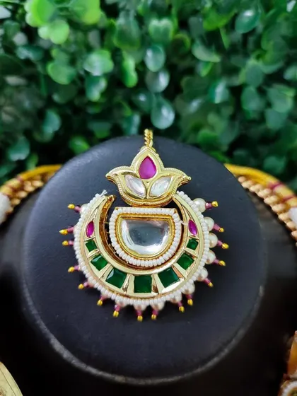 A modern maang tikka with a lotus motif, featuring pink and green enamel work. This piece is from my exclusive sale collection.
