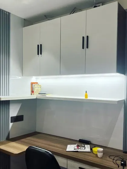 A wide view of the study room in Noida, showing the extensive desk space and storage. The fluted panels on the wall add a modern, textural element.