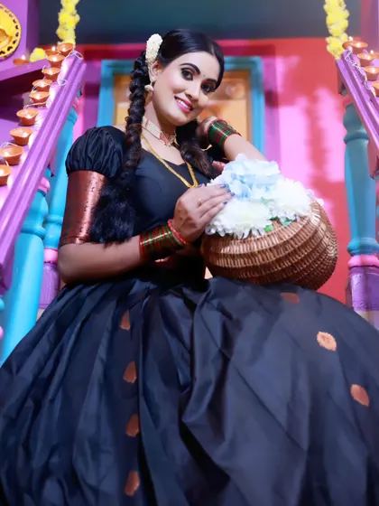 A beautiful South Indian traditional look, featuring a black and copper half-saree (Langa Voni) and traditional jewelry, perfect for festivals or cultural events.
