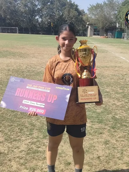 One of our players proudly displays the runners-up trophy and prize check from the JMF Pink Cup tournament.