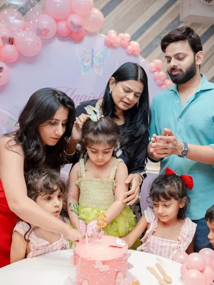 A family gathered around to help the birthday girl cut her butterfly cake. These are the sweet, shared moments that I love to be a part of.
