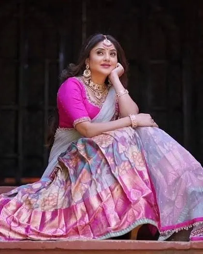 A full-length photo showing how the jewellery complements her beautiful pink and grey langa voni. It is a perfect look for an engagement or pre-wedding celebration.
