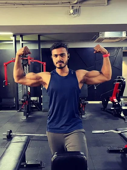 You don’t have to be extreme, just consistent. Hitting a double bicep pose at the gym. This is the result of showing up day after day, and I'll build a plan that helps you do the same.