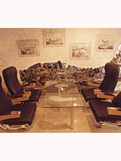 Original airplane passenger seats are repurposed for lounge seating at the Aste Bar. The design is a conversation between industrial salvage and comfortable, functional interior design.