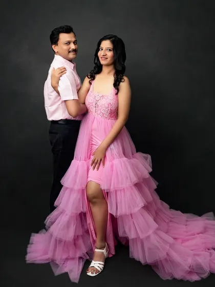 A glamorous couple's portrait in the studio. The flowing pink gown adds a touch of fairytale romance, perfect for celebrating your love story at any stage.