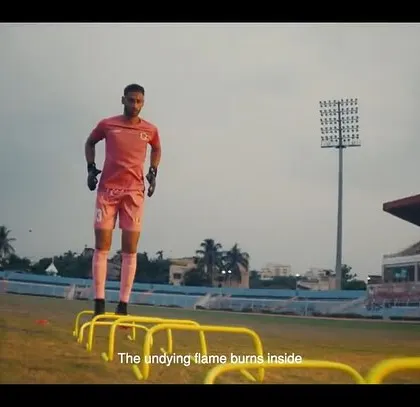 A player training on the field in the East Bengal FC ad. The focus is on his athletic form, with his training gear styled for performance.