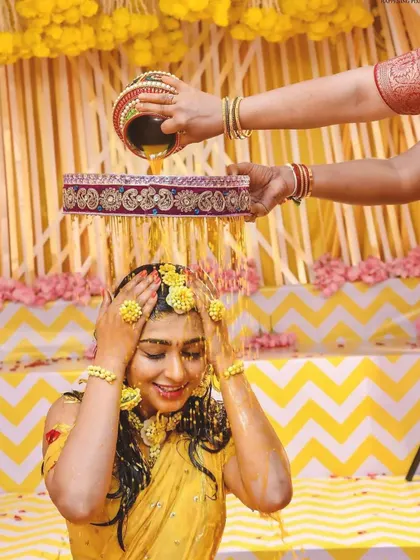 A candid moment of happiness during the Arisina Shastra. The air is filled with turmeric and flower petals, celebrating the bride in a setting I designed to be both traditional and photogenic.