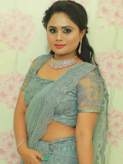A close-up of the grey saree, highlighting the sheer, embroidered sleeves of the matching blouse.