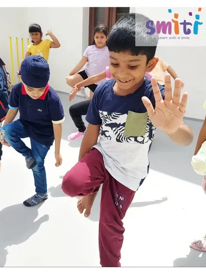 A boy smiles as he marches in place, fully engaged in a physical activity session. We believe in making fitness fun.