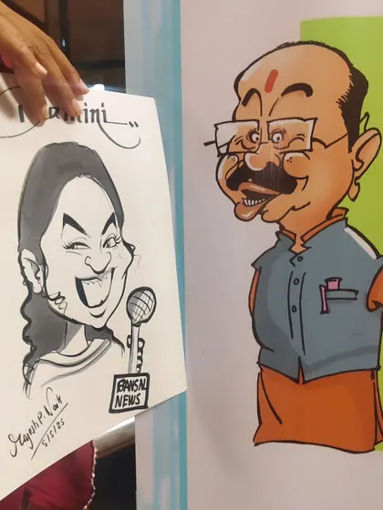 A guest holding her caricature next to a pre-existing cartoon display. It's fun to see my live art alongside other forms of cartooning.