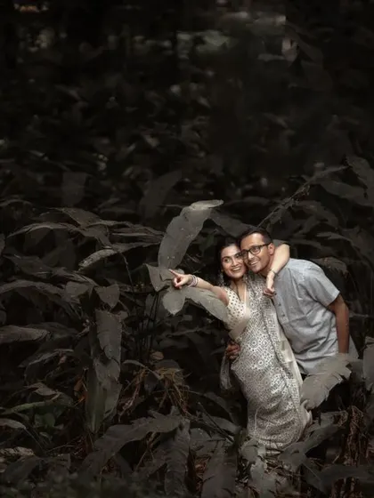 A playful moment captured during a pre-wedding shoot in a lush, green location. We believe in making our sessions fun and relaxed.