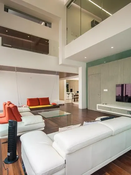 The open-plan family area connects visually to the upper levels and the outdoor garden through large glass panels.