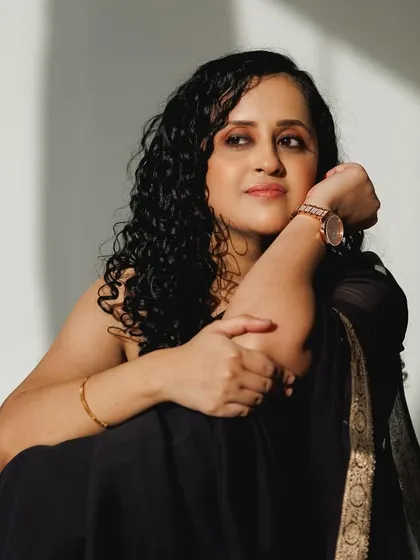 A relaxed and confident pose. The makeup is understated, focusing on healthy-looking skin.