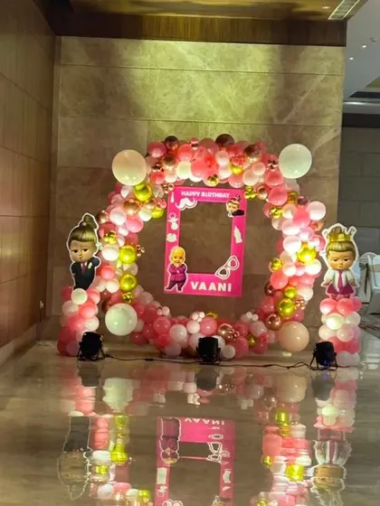 A Boss Baby themed photo booth with a circular balloon frame and a personalized selfie prop for Vani's birthday.