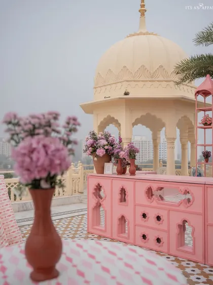 The custom-designed pink bar, with its intricate cutouts, stands against the backdrop of a traditional Rajasthani dome.