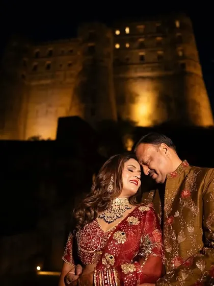 A couple celebrating their 25th anniversary shares a tender moment against the backdrop of the illuminated Alila Fort. Planning milestone events at such grand locations is one of my specialties.