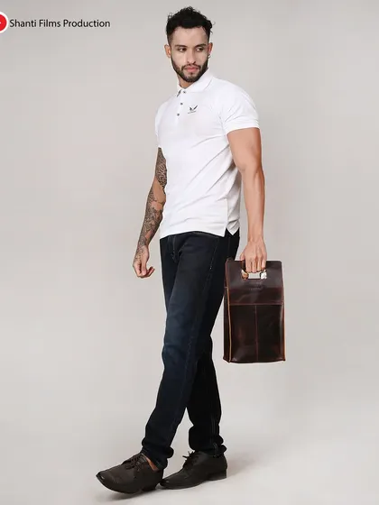 We capture accessories from multiple angles, as seen with this male model holding a leather utility bag. This helps highlight the product's handle and portability.