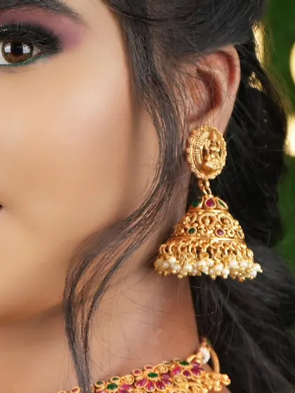 A detailed shot of a traditional jhumka with a goddess motif. I have matching jhumkas for all my temple jewellery sets.