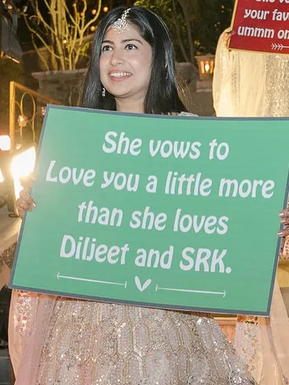 "She vows to love you a little more than she loves Diljeet and SRK." These personalized signs add so much humour and personality to a wedding entry.