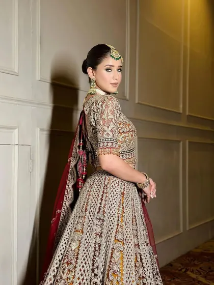 A side view showcasing the intricate embroidery and the elegant posture of the bride.