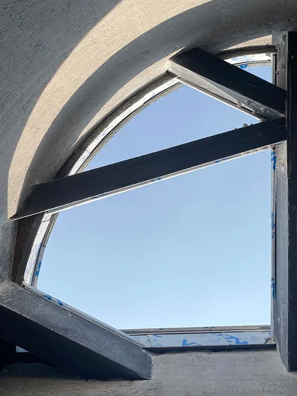 Another view of the skylight at the House of Galleries, showing the interplay between the curved opening and the angular wooden structure. The contrast between these forms creates a dynamic architectural detail.