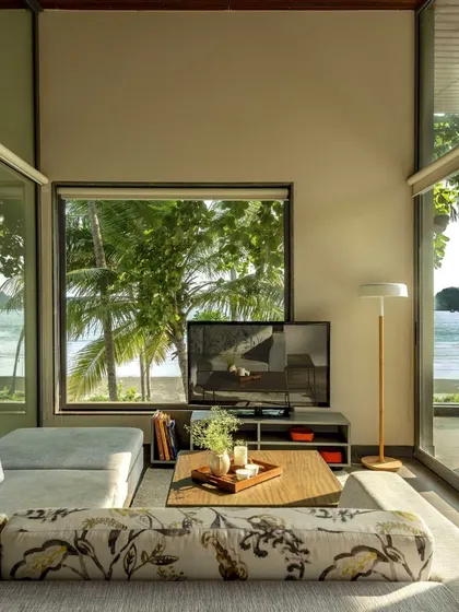 A living room with panoramic views of the ocean, where the design prioritizes the connection to nature.