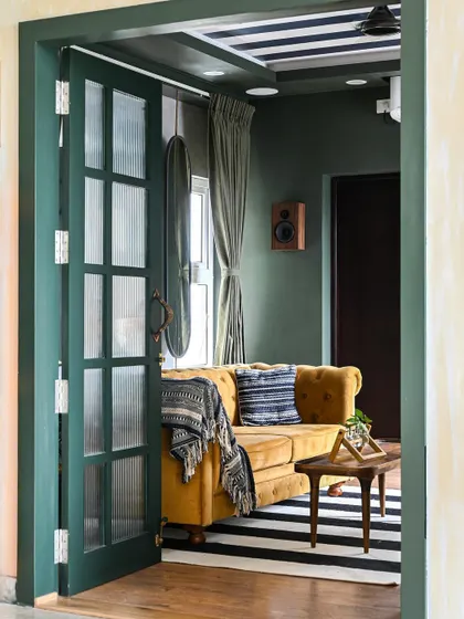 A slightly different angle of the media room entrance, highlighting the custom green-painted doors.