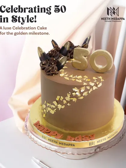 Celebrating 50 in style! This luxe celebration cake for a golden milestone is a rich chocolate creation, adorned with edible gold leaf and elegant chocolate shards.
