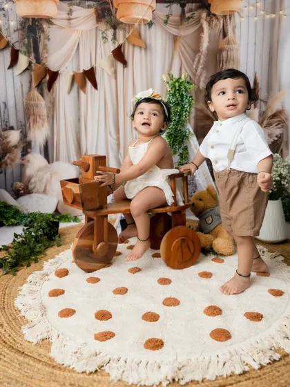 A full portrait of the two siblings with their toys in the beautifully decorated studio space.