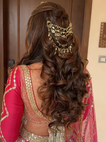 A close-up of the beautiful curls and the intricate hair accessory in this half-up style.