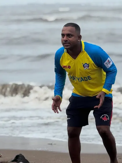 A coach stays alert and ready during a beach fielding session, demonstrating the intensity we expect from all our players.