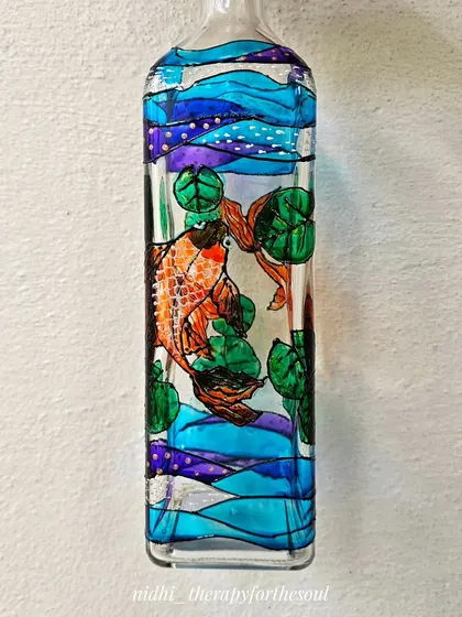 Another angle of the koi fish bottle, showing how the light passes through the blue and purple water patterns. It’s a perfect piece for a sunny windowsill.
